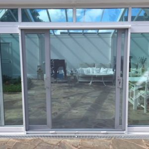 Vertical retractable insect screen door